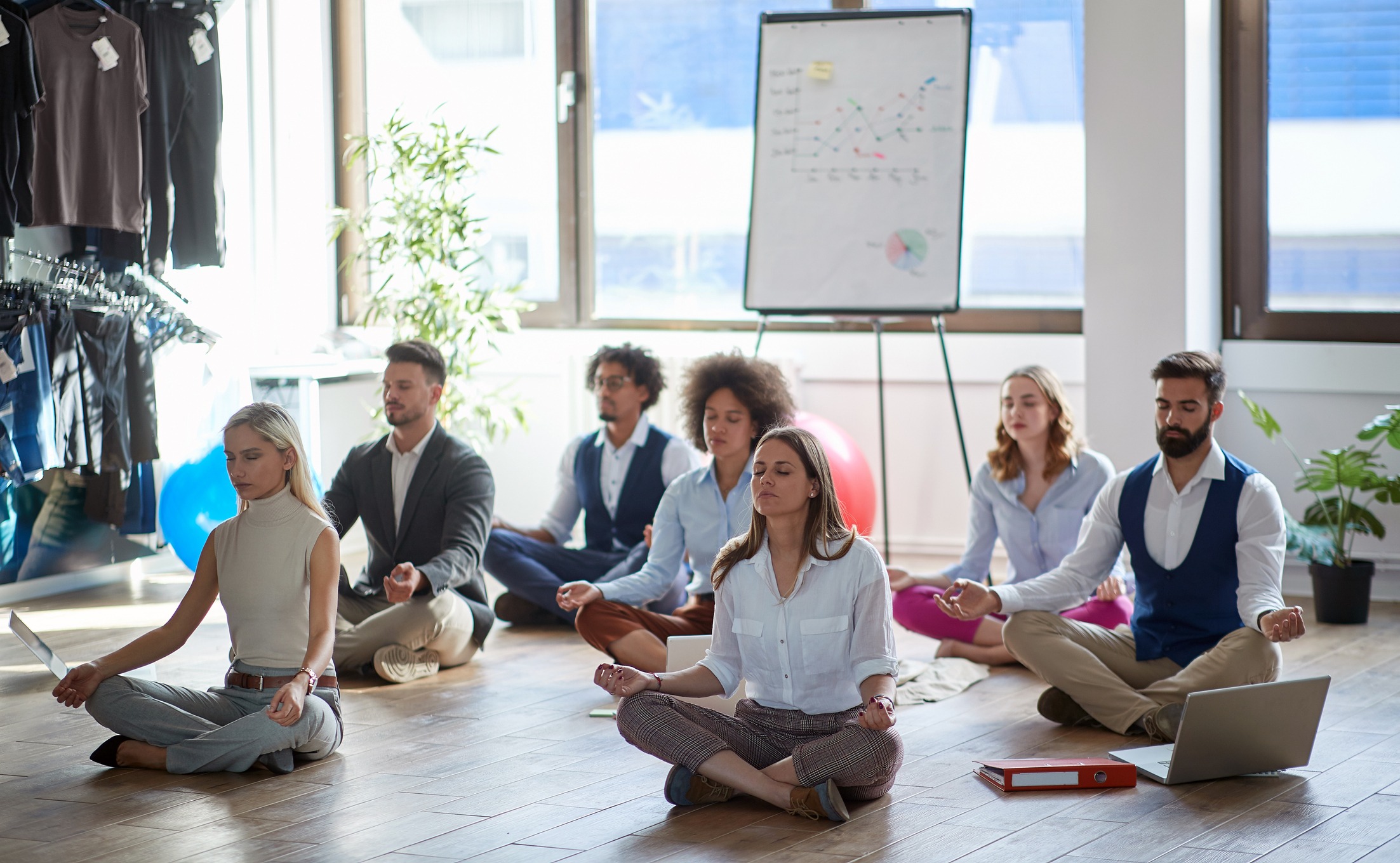 Business people practicing wellness through group meditation