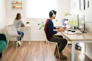 Gen z young woman and man sitting at their desks and working at the office
