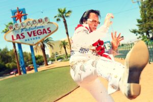 Elvis look-alike impersonator man in front of Welcome to Fabulous Las Vegas sign on the Strip
