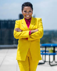 woman in yellow sport coat and pants crossing arms