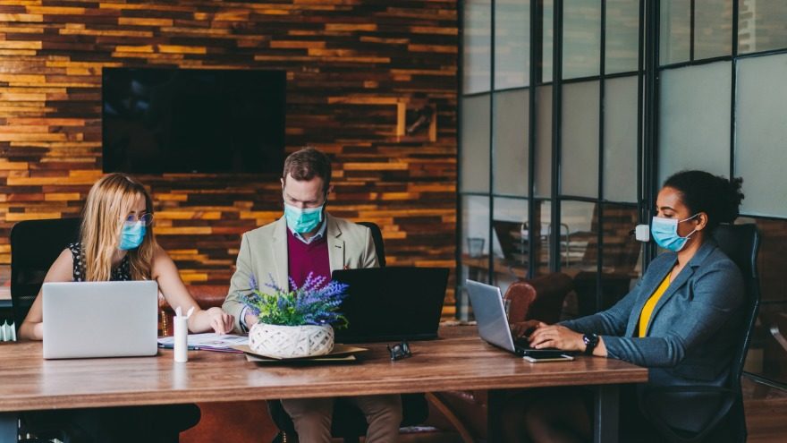 Starting a business in 2021 sees a lady in mask, presenting to her team