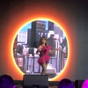 Paula Abdul performing onstage in a feathered pink dress