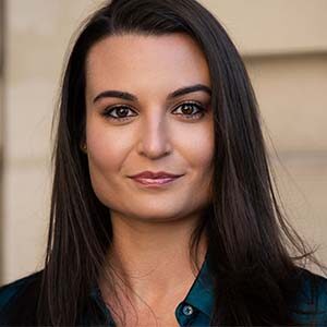 A portrait of Tiffany Alves Hafer. She is a young brown woman with long dark hair and a blue collared shirt