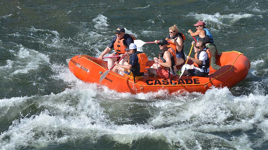 A teambuilding group working together in a whitewater raft