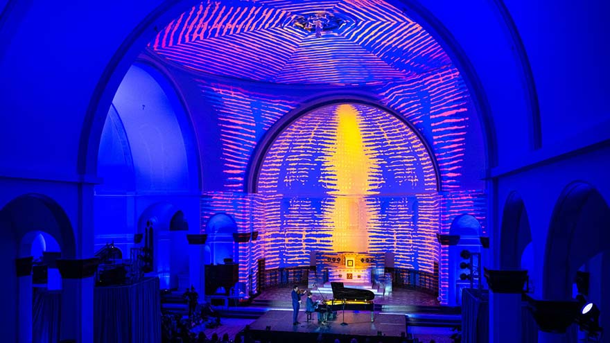 A stage in a church apse lit up blue, pink and yellow for Detroit Sessions