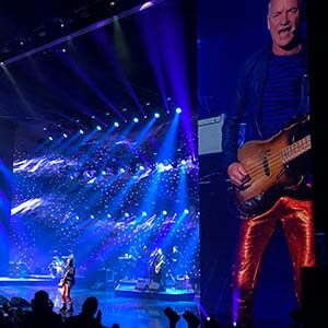Musician Sting onstage performing with a guitar