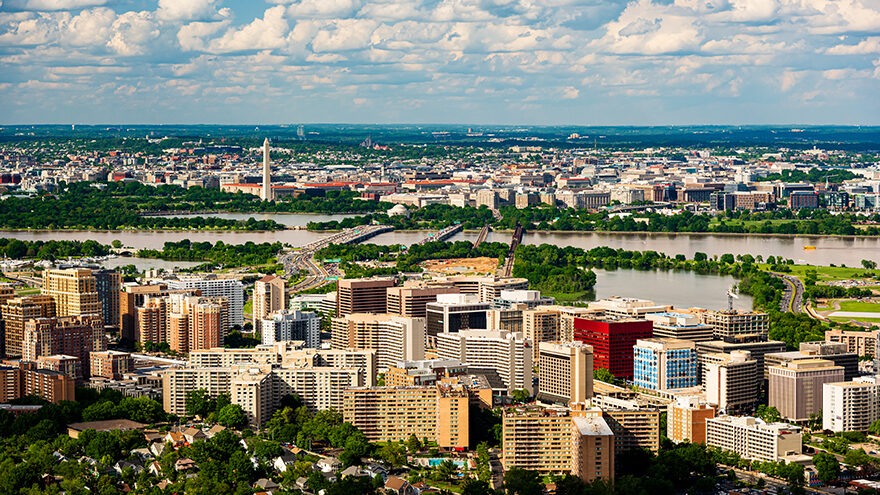 An aerial view of Arlington, Virginia. Colorful buildings are clustered between trees