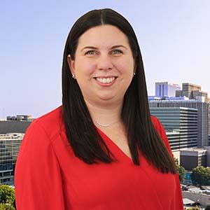 A portrait of Danielle Appley-Epstein. She is a white woman with long black hair and a red blouse