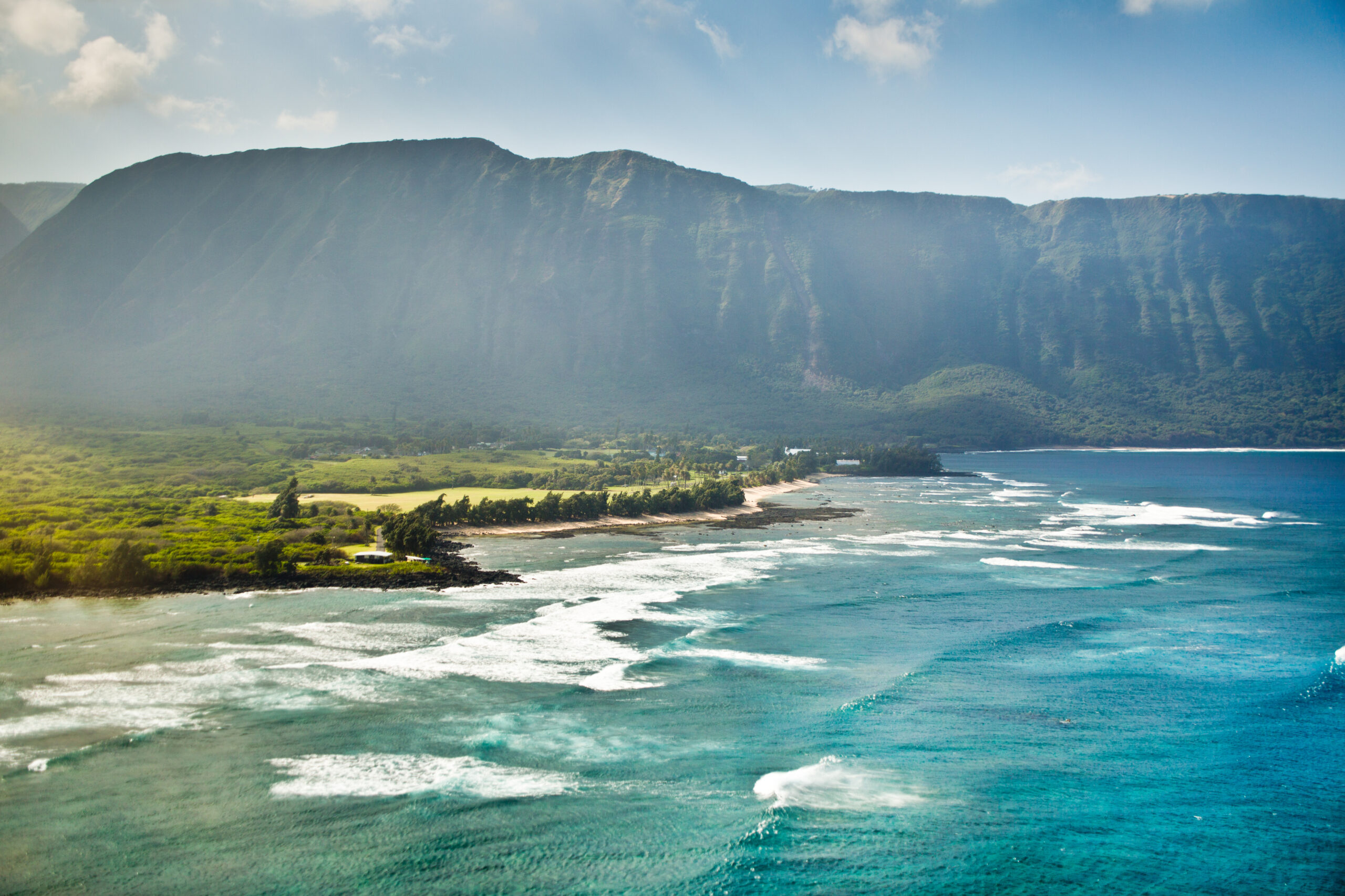 The beach of the Lepers Colony in Kalaupapa. A green mountain is in the background