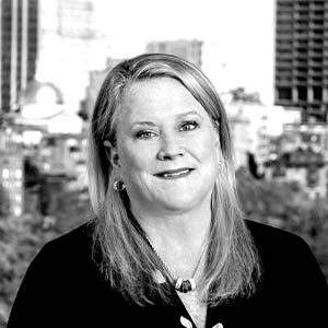 A black and white portrait of meetings professional Martha Sheridan. She is a white woman with straight hair and a black cardigan