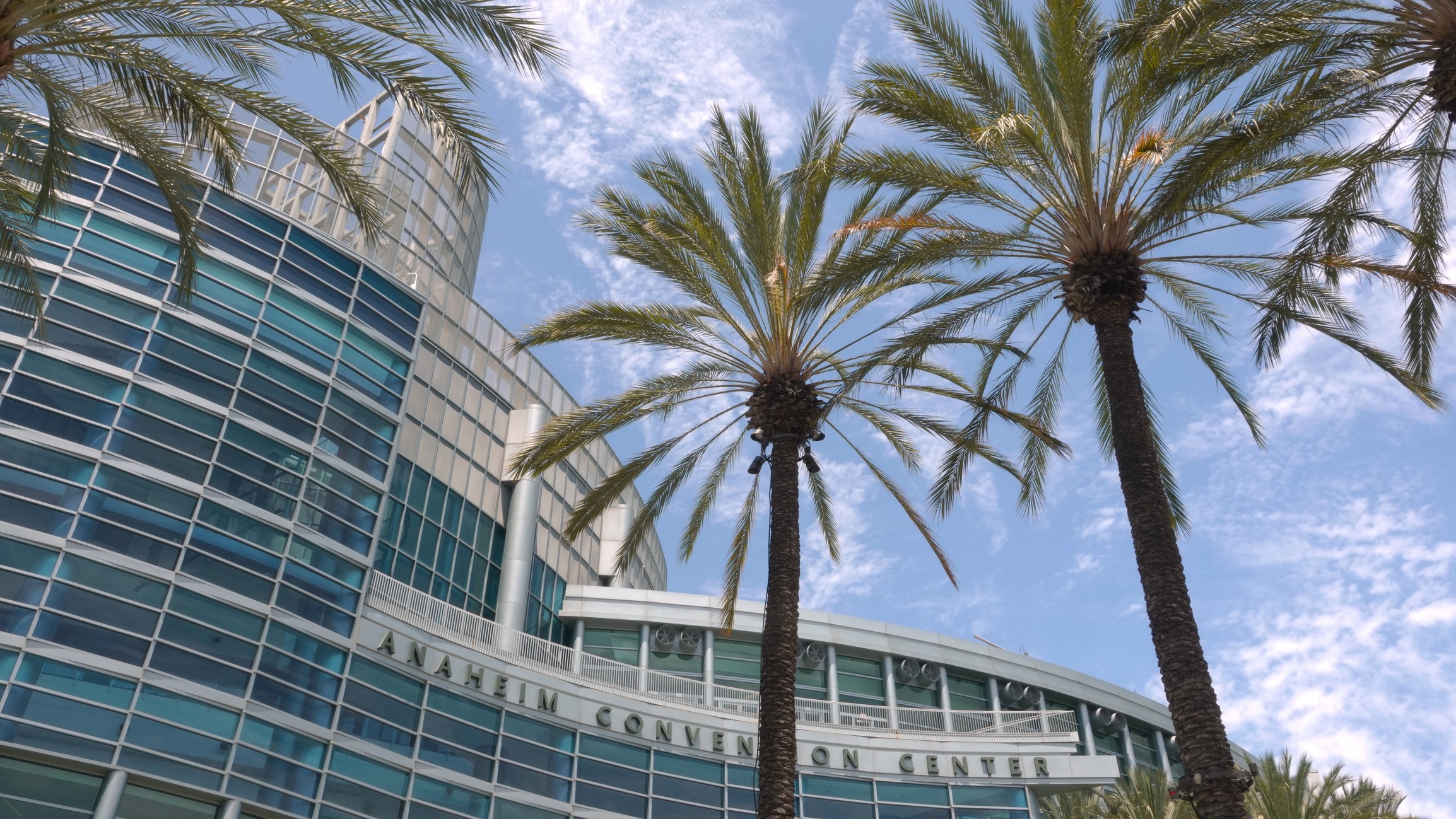 An exterior shot of Anaheim Convention Center in California with palm trees in front.