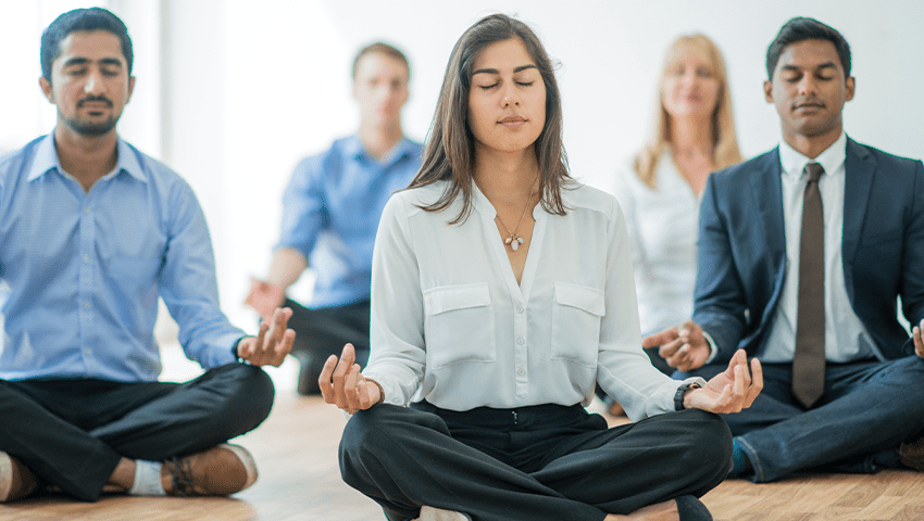 A group of business people meditating together