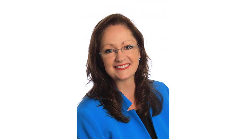 A portrait of Tammy Blount-Canavan, FCDME. She is a woman with straight brown hair, thin glasses and a blue blouse.