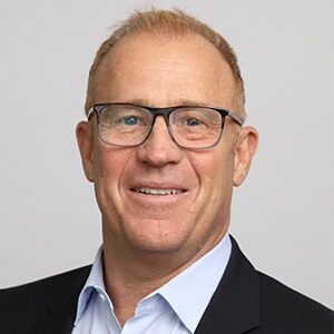 A portrait of Patrick Andersen, the new CEO of CWT. He is a white man with short red hair and square glasses.