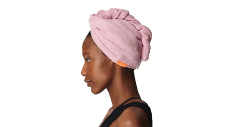 A black woman in profile wearing a pink Aquis hair wrap towel.