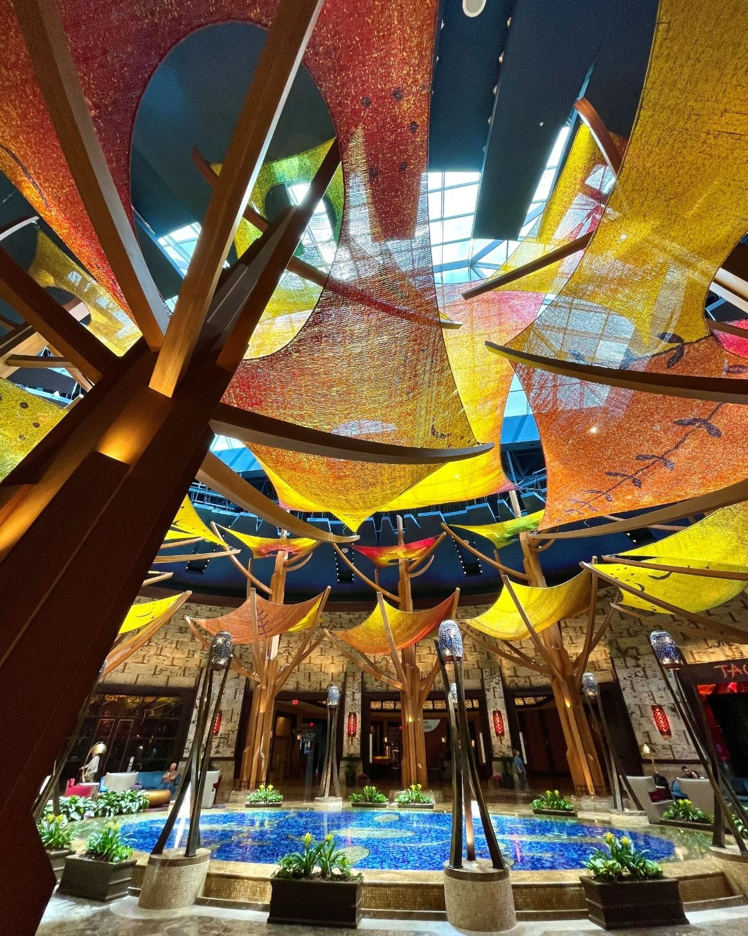 One of the indoor pools at Mohegan Sun Casino & Resort. A series of transparent red and yellow cloths made to look like tree leaves filter light from a glass atrium.