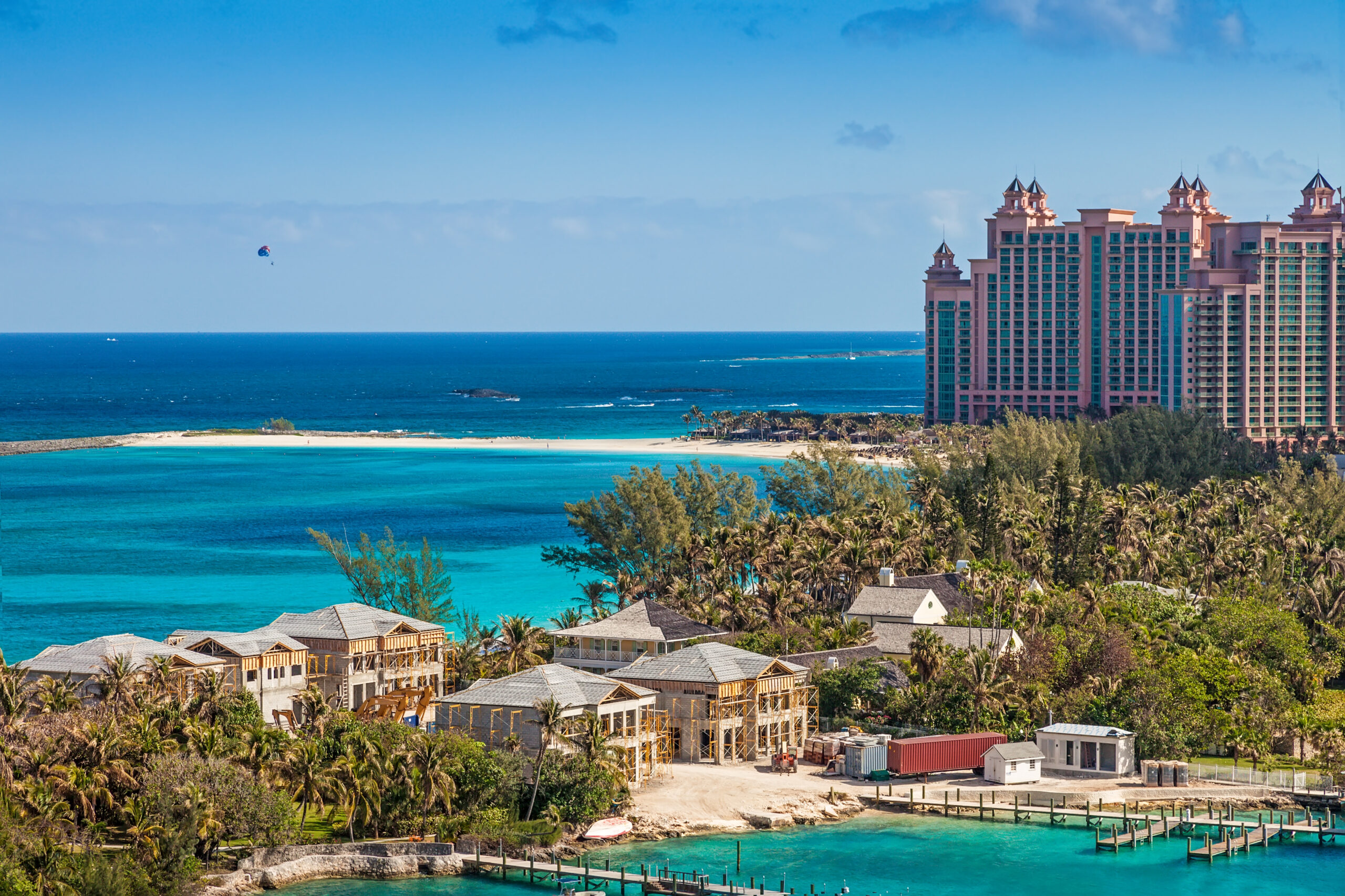 Paradise Island in Nassau, Bahamas. A pink Caribbean resort is behind palm trees and smaller buildings.