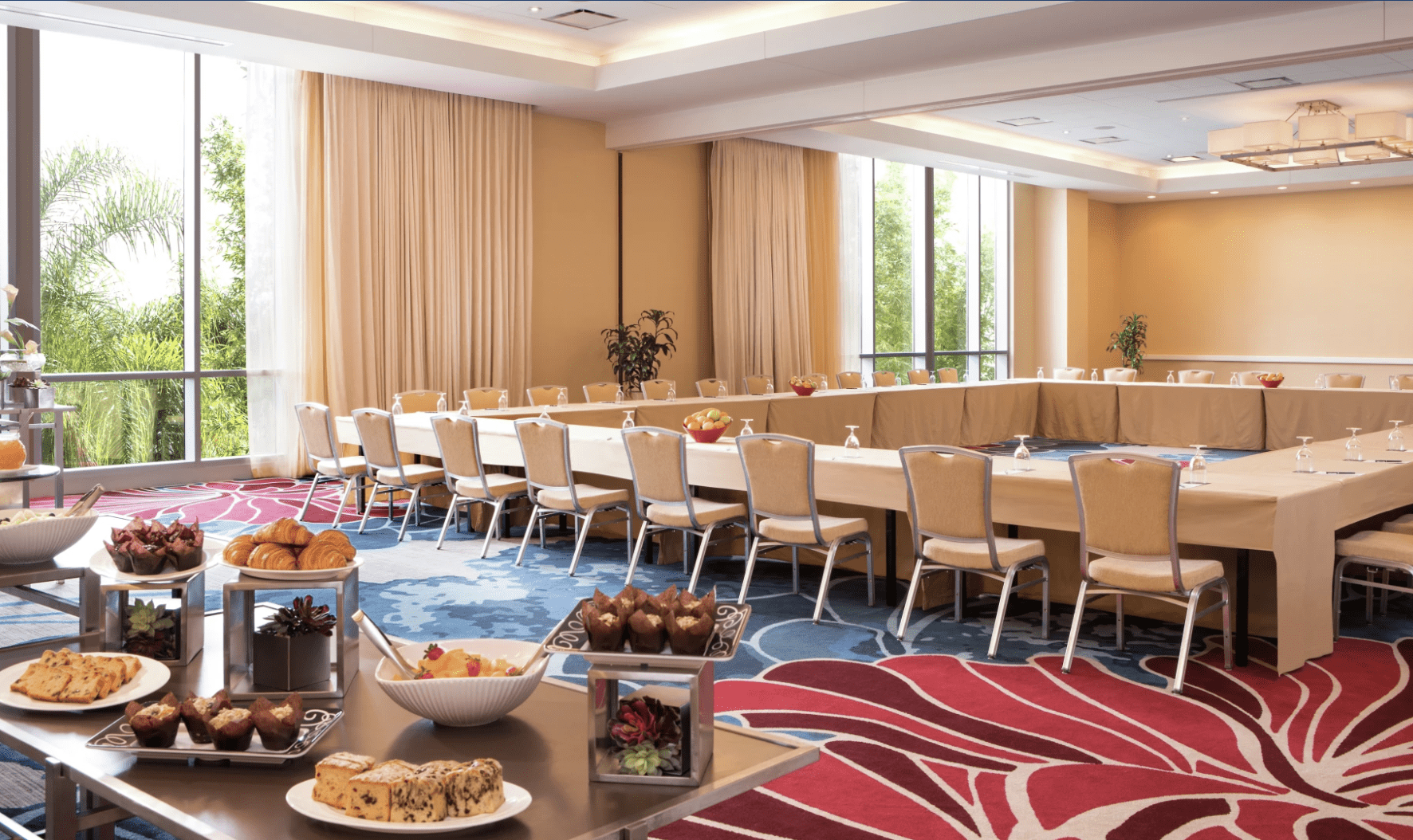 A meeting room in Hilton Orlando with a large square table and catering table. For fun retreats, their hotel-sized escape room is worth trying.