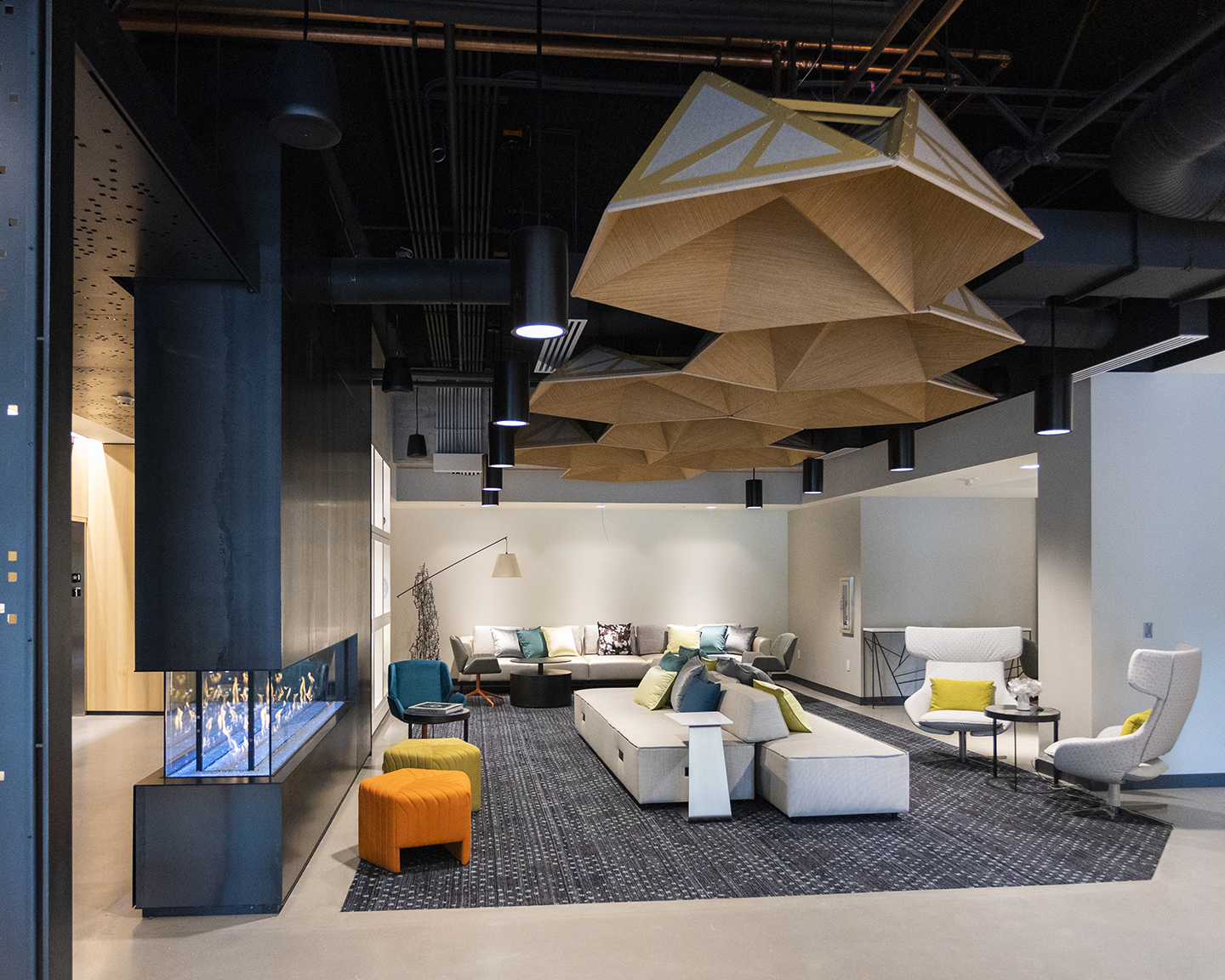 The lobby of Astra Hotel Seattle. Large brown light fixtures are above white furniture