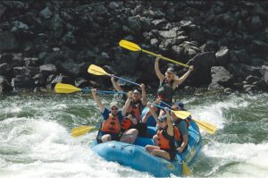 seven people in a blue raft moving through rapids in boise, idaho