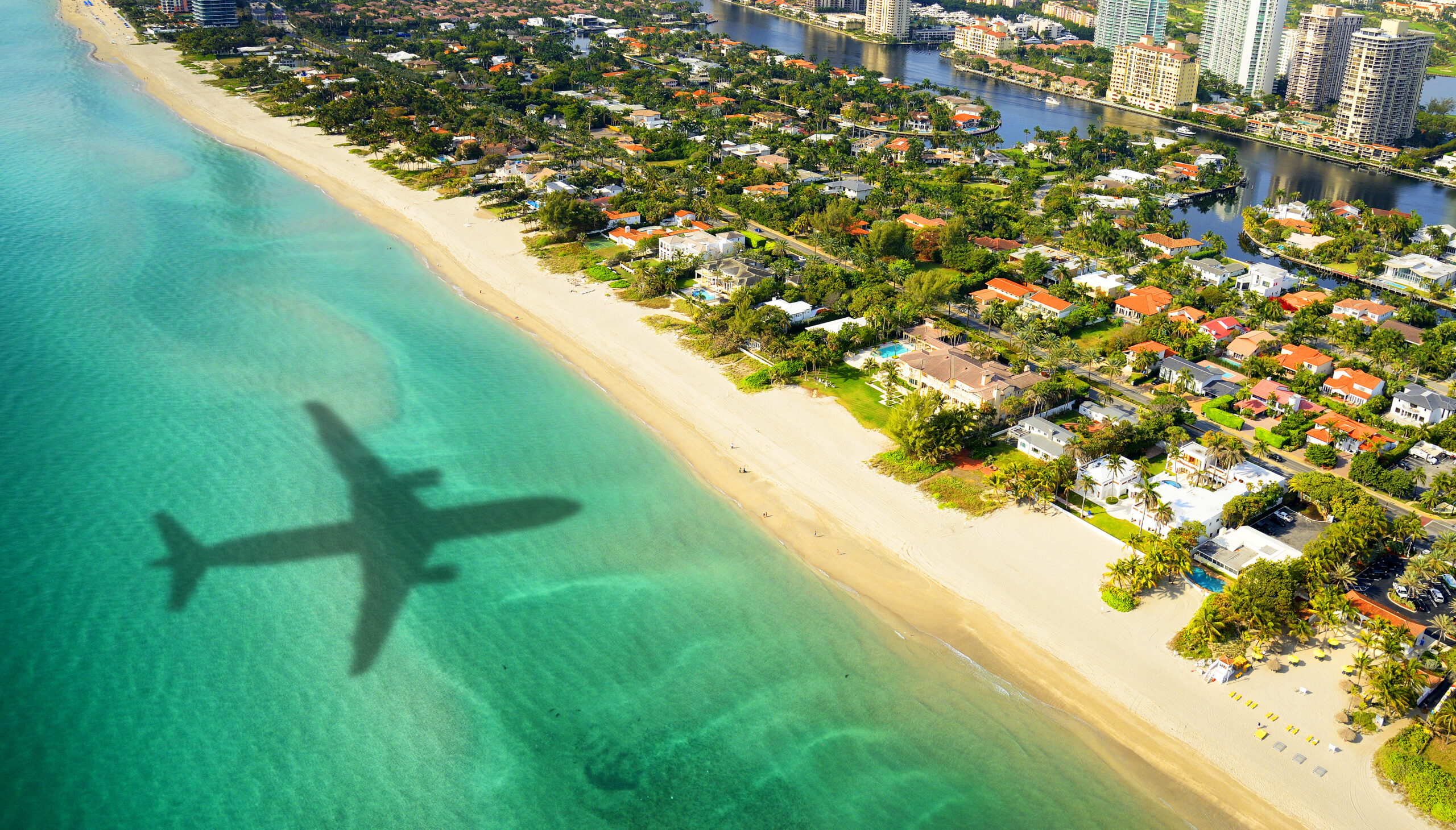 shadow of airplane flying toward coast of miami