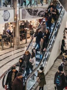 people moving down escalator in Mall in Canary Wharf in London