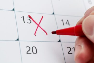 person crossing out date on calendar