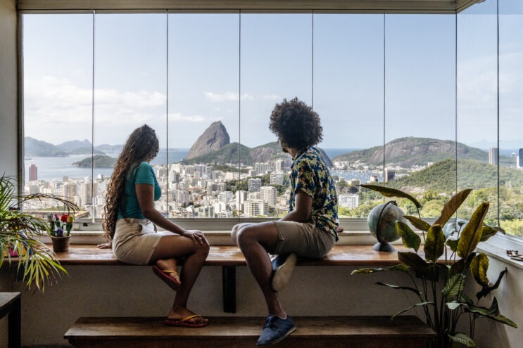 Couple sitting by window and looking at the view of Rio de Janeiro