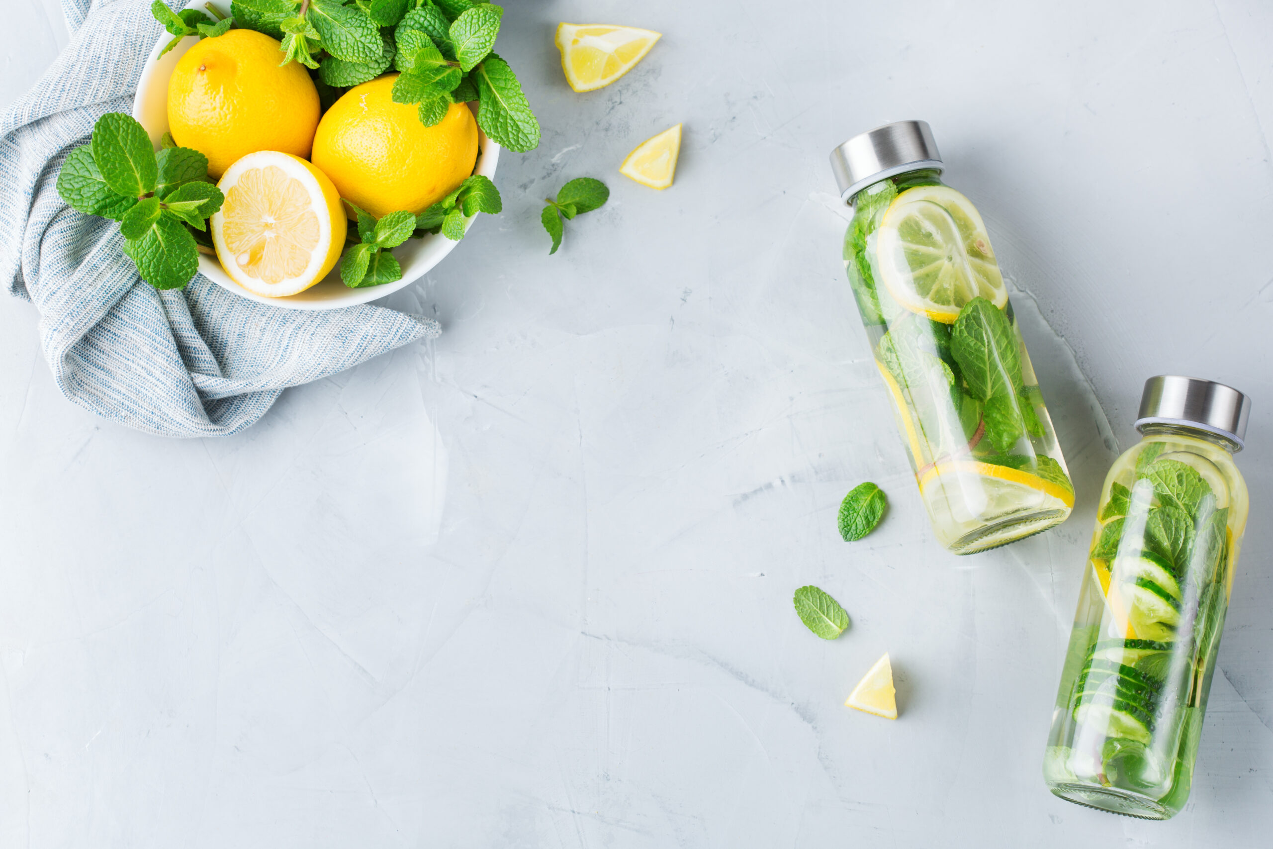 two water bottles filled with lemon, mint and cucumbers