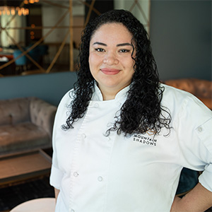 yulissa acosta with black curly hair and white chef shirt