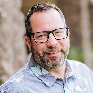 aaron bambling, wearing glasses and wearing blue dress shirt