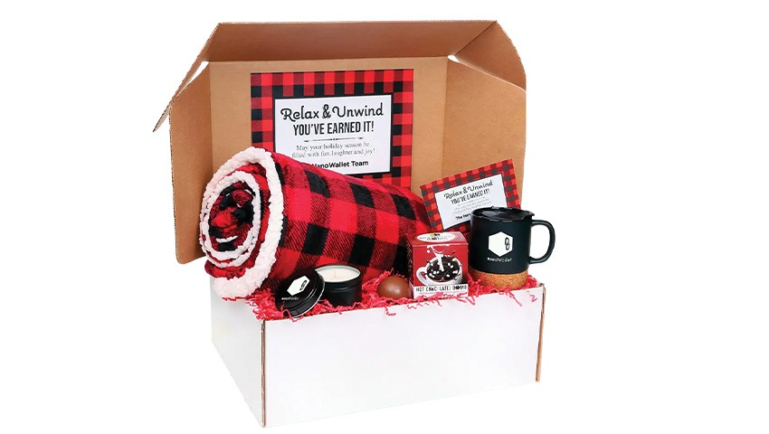 box filled with products, including a red plaid cover, mug and candle