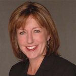 headshot of carole manning kim wearing dark brown blazer on light brown background