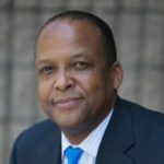 headshot of darren green wearing blue suit and blue tie