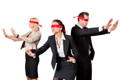 three blindfolded businesspeople reaching out