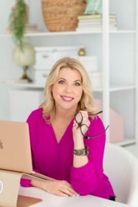 jacqueline whitmore sitting at desk, wearing purple shirt