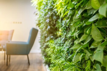 wall of green plants next to seats in conference room