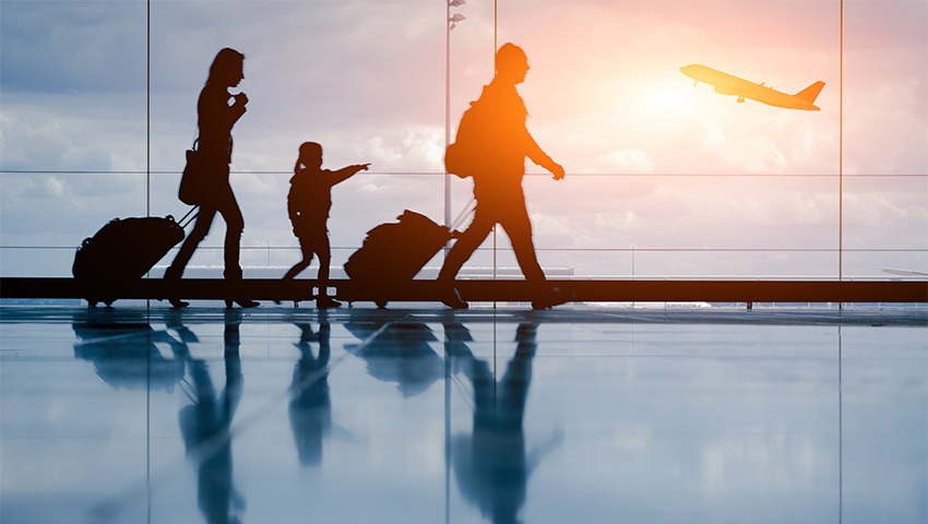 Silhouette of young family at airport and airplane in background