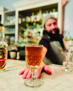 bartender pushing cocktail towards camera