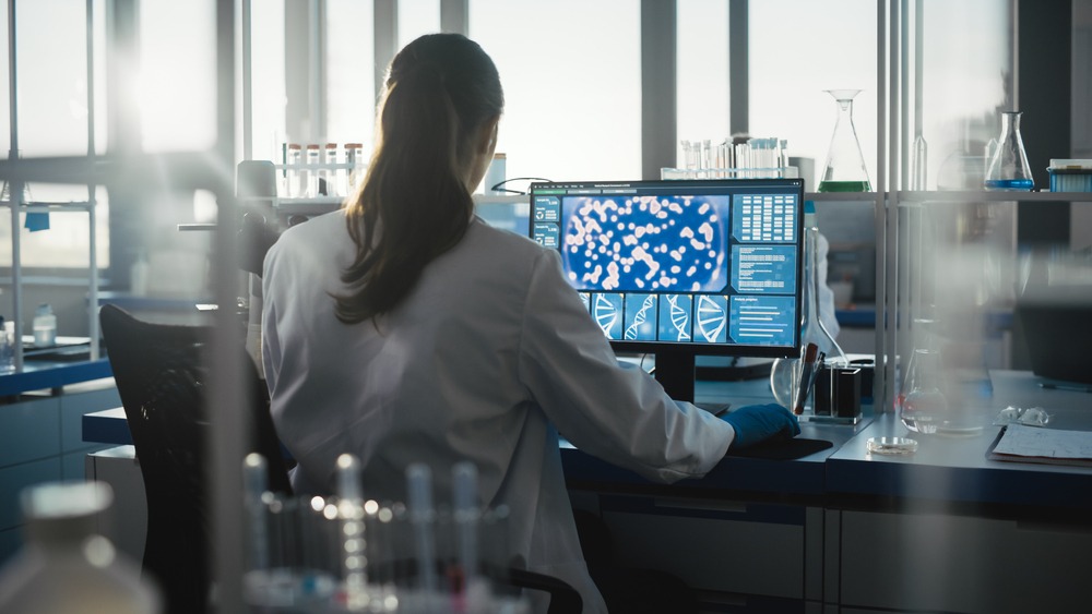Female Biochemist Working on Computer Showing Gene Therapy Interface