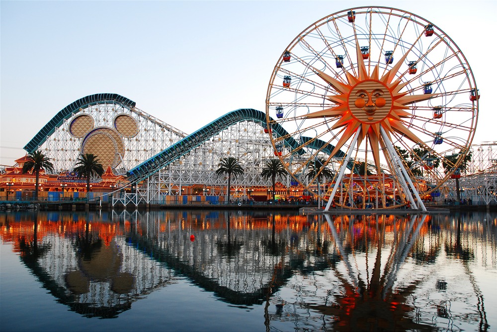 The Ferris Wheel, roller coaster and rides of Paradise Pier in Anaheim, California, are reflected in the lake