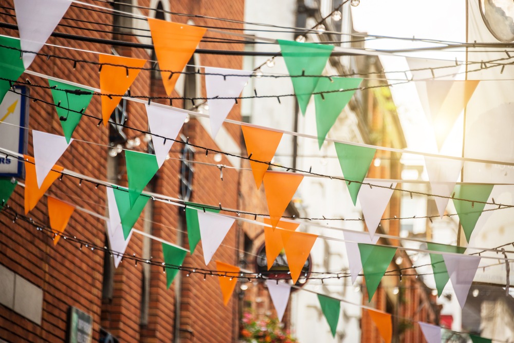 numerous irish flags hanging in a neighborhood