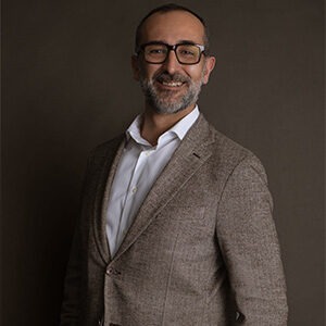 Juan Samso wearing white dress shirt and brown sport coat