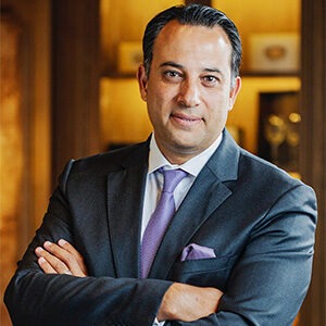 Yazan Latif wearing blue suit and purple tie