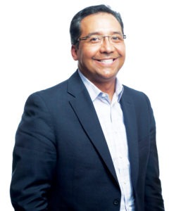 Michael Dominguez, CEO of ALHI in a blue suit.