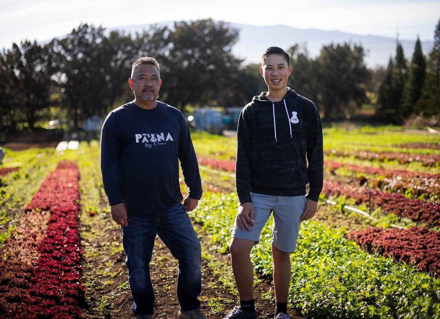 two people posing in from of farm