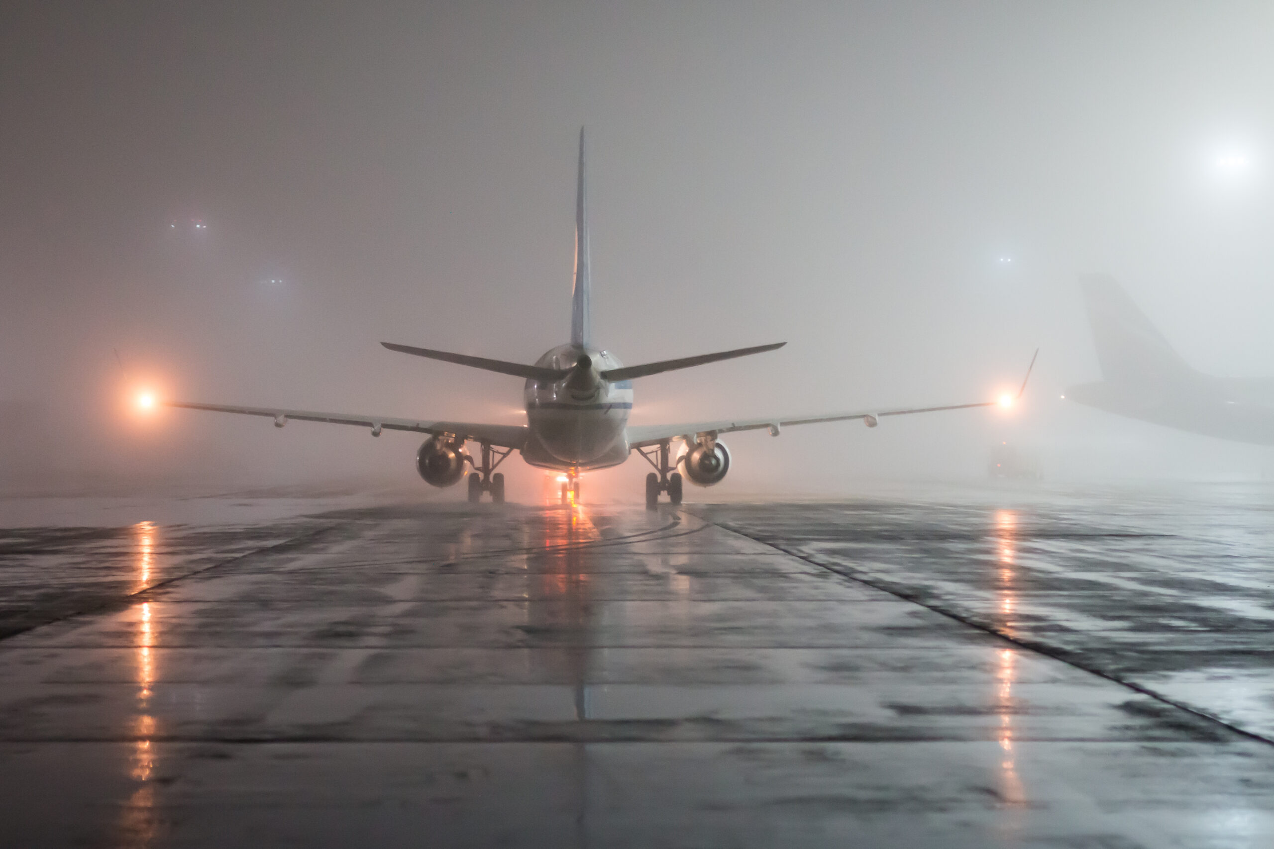 runway foggy night, view of the plane from the tail