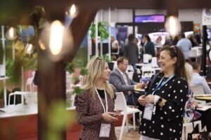 Two attendees talking on show floor at IMEX America