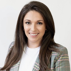 woman wearing grey and yellow plaid coat and white shirt