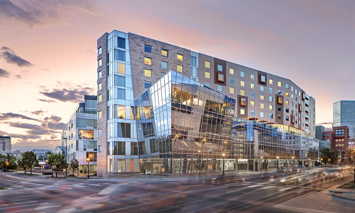 New and Renovated Exterior of The Art Hotel in Denver against a sunset sky